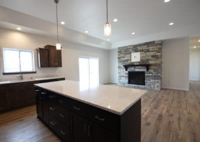View of kitchen and living space with gas fireplace with wood floors