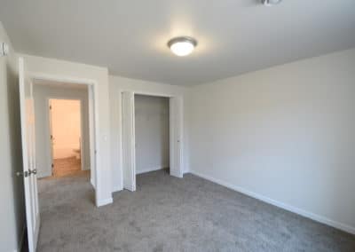 View of interior of lower level bedroom facing closet and entry