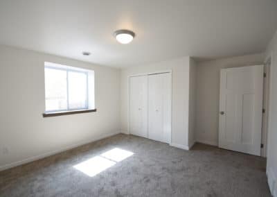 View of interior of lower level bedroom facing closet and entry
