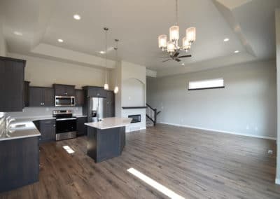 View of kitchen island, kitchen, cabinets, countertops, and living area