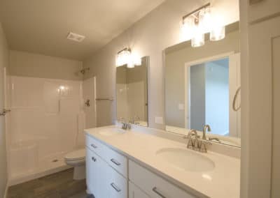 View of dual vanity sinks and walk in shower