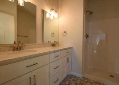 View of bathroom with double vanity and walk in shower