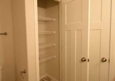 View of bathroom closet with wire shelves